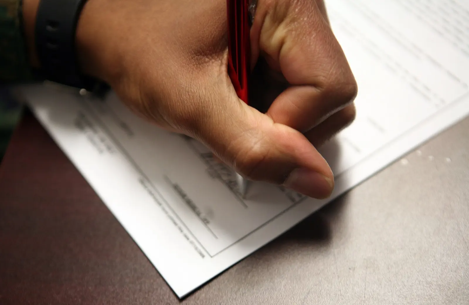 Main qui remplit un document au stylo